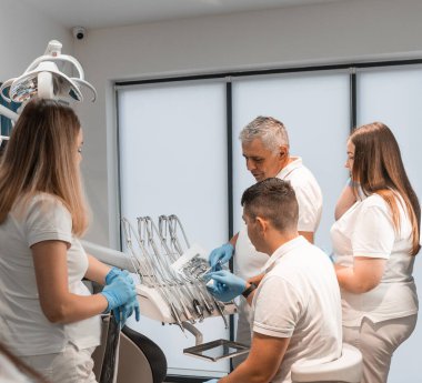 Diş hekimlerinden oluşan bir ekip hastaların ağızlarının MR görüntüsünü inceledi ve tartıştı. Diş sağlığı kliniği implantlar, kaplamalar ve diş tedavisi hizmetleri sunar. Profesyonel yaklaşım. Yüksek kalite fotoğraf