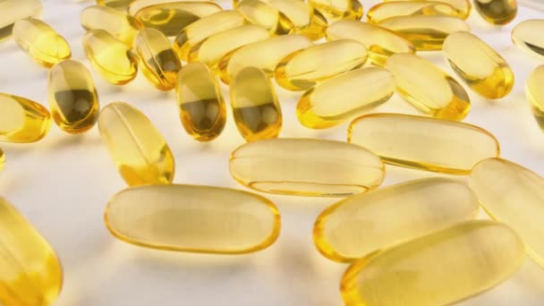 Yakın Plan Beyaz Arkaplandaki Kapsüllerdeki Vitaminler Besin Takviyeleri Sarı Altın — Stok video