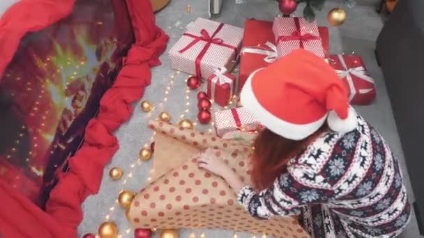 一个年轻的女人非常注意为她心爱的人包装一份新年礼物 她试图使每一个细节都具有独创性和可读性 圣诞节和寒假的气氛 高质量4K — 图库视频影像