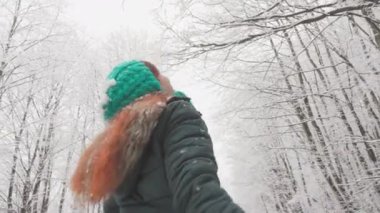 Bu genç kadın kış yürüyüşü bir peri masalı dünyasına dönüştü. Karla kaplı ağaçlar tatil için süslenmiş gibi görünüyor. Bu büyüleyici ormanda attığı her adımdan zevk alıyor.