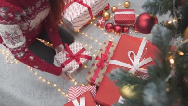 彼女の手にクリスマスの休日の儀式のためのカラフルなギフトを包む陽気な女性は さまざまな紙に包まれて環境に優しい材料で作られた明るい箱です 高品質の4K映像 — ストック動画