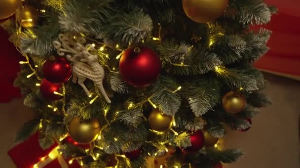 クリスマスツリーとギフトは 休日の魔法で部屋のすべての領域を満たすクリスマスインテリアの中心です クリスマスツリーランタンの光が部屋を満たします — ストック動画