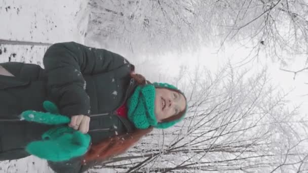 一个年轻的女人喜欢在雪地的公园里散步 度过一个冬天 在大自然中一段孤独和放松的时光 注意到冬季美景的每一个细微细节 她的脸上流露出一种平静和满足的神色 — 图库视频影像