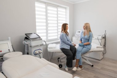 Uzman etkileşimi: Profesyonel bir kozmetik uzmanı ve bir müşteriyle kozmetik bakım ve doğal ürünlerin görüşüldüğü bir güzellik kliniğinde buluşmak. Yüksek kalite fotoğraf