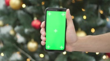 Aydınlatılmış bir Noel ağacı ve akıllı telefon, tatil sezonu boyunca çevrimiçi alışveriş ve rezervasyon rehberidir. Yeşil ekran ve kromakey etkisi. Yüksek kalite 4k görüntü