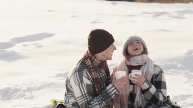 Mutlu bir genç adam ve kız arkadaşı piknikte bir kış gününün getirdiği tüm duyguların şefkatini ve neşesini hissederler. Kardan bir battaniyenin altında, çift sıcak bir içecek tutuyor ve gülümsüyor.