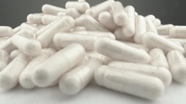 Kapsül biçimindeki vitaminler her gün için güç ve enerjiye giden yoldur. Beyaz kapsüllerin yavaş dönüşü tedavinin ve tıbbın önlenmesinin bir sembolüdür. İlaç Sanayisi