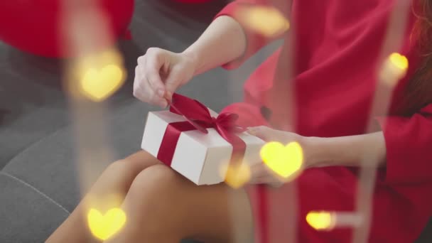 彼女は贈り物を開けるときに驚き 彼女の目に輝きを見ます ハッピーバレンタインデー それぞれの贈り物は 私たちの無限の愛の象徴です 高品質の4K映像 — ストック動画