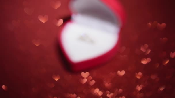 Förlovningsringen Ligger Elegant Ask Röd Bakgrund Med Glitter Beläggning Denna — Stockvideo