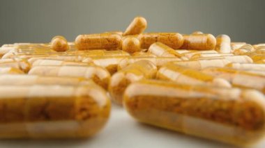 Sağlığı desteklemek için kapsül formunda vitaminler ve besin takviyeleri. Besin değeri olan kapsüller beyaz bir zemin üzerinde döner. Sağlığın korunması ve iyileştirilmesine yönelik ilaçlar ve vitaminler