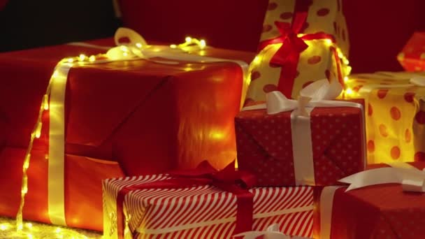 贈り物や装飾の深く豊かな赤い色は クリスマスの暖かさと調和の象徴です クリスマスツリーの下には この特別な時期にあなたを喜ばせる準備ができている多くの贈り物があります — ストック動画