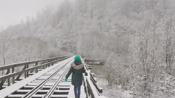 Una Joven Mujer Cruza Puente Cubierto Nieve Tratando Perder Equilibrio — Vídeos de Stock