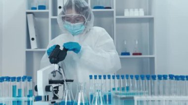 Bulaşıcı hastalıklarla savaşmak için aşı üretme ve test etme süreci. Bilim adamları hastalıkları önlemenin yolları üzerinde çalışıyorlar. Bilim adamı, hücreleri ve molekülleri ayrıntılı olarak incelemek için bir mikroskop kullanıyor.