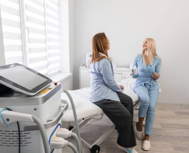 Kozmetik becerileri: Profesyonel bir kozmetik uzmanı, kaplıca kliniğinde çalışan bir kadına kozmetik problemleri ve doğal cilt bakım ürünlerinin seçimi hakkında tavsiyelerde bulunur. Yüksek kalite fotoğraf