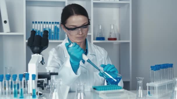 研究人员正致力于利用尖端技术和分子生物学来开发新的治疗方法 他从化学实验室的一个瓶子里拿起一个放药的长笛 — 图库视频影像