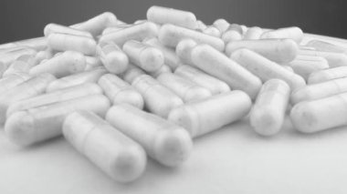 Platformda dolaşan kapsüller, ilaç endüstrisindeki önleme ve tedavi potansiyelinin kilidini açıyor. Beyaz tıbbi kapsüllere yakın çekim. İlaç ve beslenme takviyeleri.