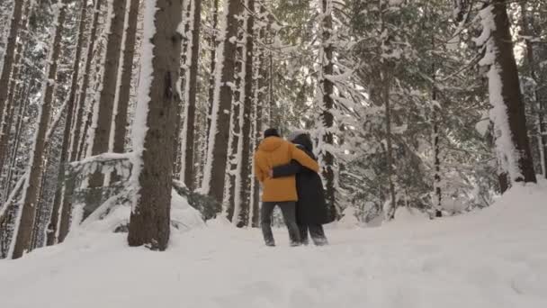 サンライズの若いカップルは予期せぬ冬の休暇と予測できない楽しい瞬間を楽しんでいます 森の中を歩く若い家族 冬に恋をするカップル 高品質の4K映像 — ストック動画