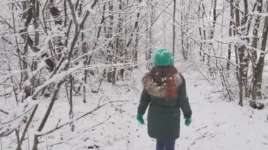 Karla kaplı orman genç bir kadın için sessiz bir yürüyüş yeri haline geldi. Karla kaplı olan ormanın uzun ağaçlarının altındaki yumuşak kar üzerinde yürür. O heybetli baktı.