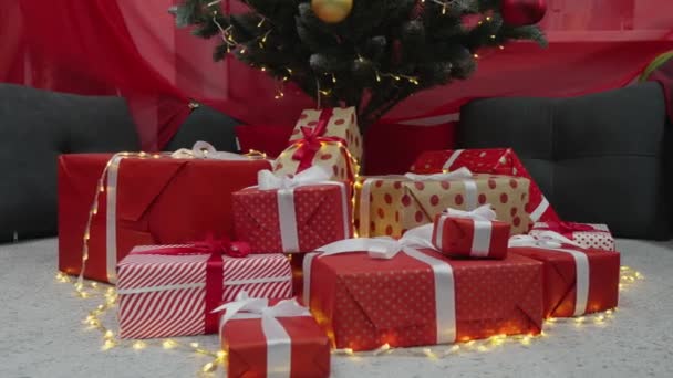 クリスマスツリーの下には 忘れられない喜びと感動の瞬間を約束する贈り物があります ギフトボックスには愛する人のための触れ合いとケアが詰め込まれています クリスマスのおとぎ話はすべてから始まります — ストック動画