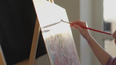 Bir sanat stüdyosunda soyut yaratıcılık. Renkli bir palet, yaratıcı araçlar ve sanatçı dokunuşu tuvalde eşsiz görüntüler yaratır. Soyut resimlerin yakın plan çizimi. Yüksek kalite 4k görüntü