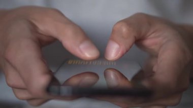 Elimizde iş var. Başarılı bir iş adamı finansal verileri gözden geçirir ve akıllı telefonunu modern bir iş yeri olarak kullanarak stratejik planlama yapar. Haberleri kaydırıyorum. Yüksek kalite 4k görüntü