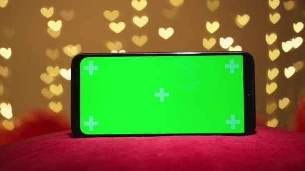 グリーン スマートフォン スクリーン クロマのキー効果 ハートがぼやけた光で背景 バレンタインデーとバレンタインデーのコンセプト オンラインで注文と予約 アプリとウェブサイトはプロモーションを提供しています — ストック動画
