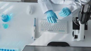 Yukarıdan bak. Tıptaki yeniliklerin merkezi olan bir laboratuvarda çalışan gerçek bir bilim adamı. Mikroskop altında, hücrelerin özelliklerini inceler ve bilgisayar analizi araştırma gerektirir.