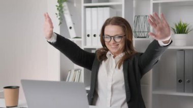 Businesswoman in the office: The workday is filled with successful solutions and technological improvements. Successful completion of the project and work. The joy of the completed task and deeds. End