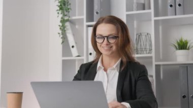 A businesswoman in a stylish office: successful, dynamic and always at the forefront of events. A successful female leader rejoices in an achievement. Female student and student of business university