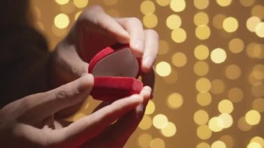 This engagement ring is the key to their future happiness and unforgettable love story. The concept of giving gold ring jewelry. Engagement and marriage proposal. Valentines Day Gift. High quality 4k