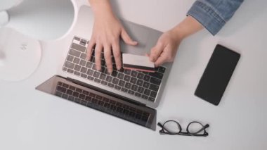 Online mağazanın kişisel hesabındaki kız, alım-satım işlemlerinin basitliğini ve güvenliğini sağlamak için kredi kartı kullanıyor. İnternetteki dizüstü bilgisayardan satın almanın en üst görünümü