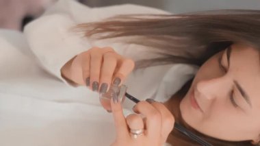 Dikey video randevudan dakikalar öncesini gösteriyor. Kadın kozmetik uzmanı yaratıcı süreç için hazırlanıyor. Güzelliğin nabzında duruyor, aletlerini hazırlıyor ve son nefesini veriyor.