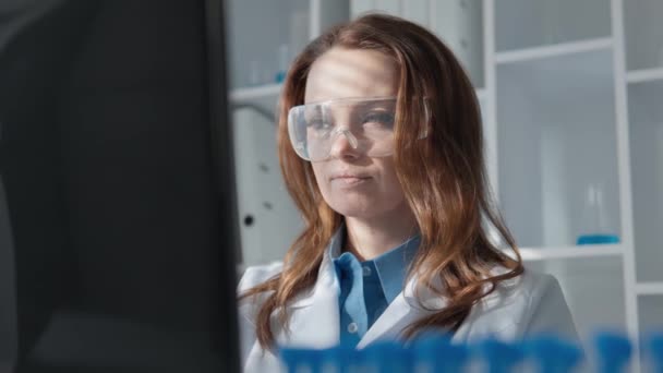 化学者がコンピュータで働く化学研究所では 新しい医薬品ソリューションを開発するための実験が進行中です 顕微鏡の下で 彼女は化学プロセスを研究し そして — ストック動画