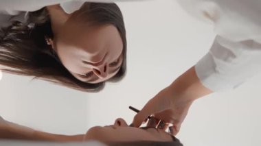 Güzellik salonunda lüks ve ultra bakım. Kozmetik bilimci, laminasyondan bakım ürünlerinin kullanımına kadar her bir müşterinin mükemmel koşulunu sağlamaya çalışır. Yüksek kaliteli FullHD görüntüleri Dikey video.