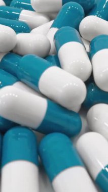 Kapsül şeklinde profesyonel gıda takviyesi üretimi. Mavi ve beyaz hazırlıklar. Tıbbi bir arka planda vitaminler ve kapsüller: sizin iyiliğinizi önemsiyoruz. İlaçlar Vitaminleri