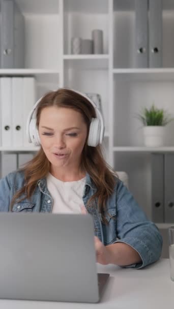 그녀의 노트북에 웹캠을 헤드폰에 여자는 생산적인 통화를 합니다 그것은 고객과 — 비디오