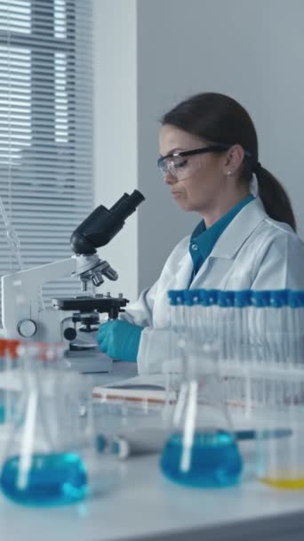 実験室の実験遺伝学者は顕微鏡で働き さまざまな疾患の治療のための遺伝療法の新しい方法を開発する 高品質のフルHd映像 — ストック動画