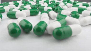 Uyuşturuculu yeşil-beyaz kapsüller. Endüstriyel ilaç üretimi. Hastalığın tedavisi için. Gıda katkı maddelerine sahip kapsüller: ilaçlarda sağlığın korunması ve geri kazanılması