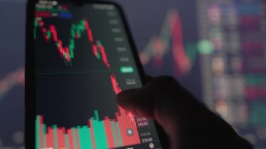Ticaretinizi bir sonraki seviyeye taşımak için mobil bir uygulamayla tüccarlar için. Bu videoda elleriniz akıllı bir telefonu tutarken ve online ticaret grafiklerini etkin bir şekilde çevirirken izleyin.