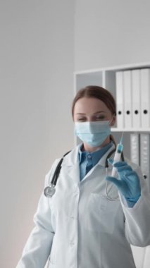 Çalışmalarında profesyonellik ve özen gösteren, enjeksiyona hazırlanan bir doktor, elini ve parmağını kullanarak bilgi eklemek için bir yer gösteriyor. Doktor gösteriler ve reklamlar yapar. Yüksek kalite
