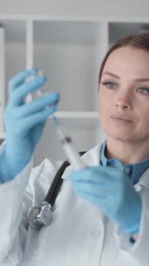 Doktor şırıngayı ilaçla dikkatlice doldurarak en son ilaçları kullanarak tedavinin güvenliğini ve etkinliğini garanti altına alan tıbbi prosedüre hazırlanıyor. Yüksek kaliteli FullHD görüntüler