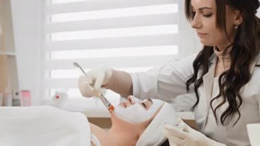 Kozmetik prosedür maskesi: Bir kozmetik uzmanının güzellik salonundaki durumunu ve görünümünü iyileştiren yararlı bileşenlerle zenginleştirilmiş bir cilt yenileme ürünü. Yüksek kalite 4k görüntü