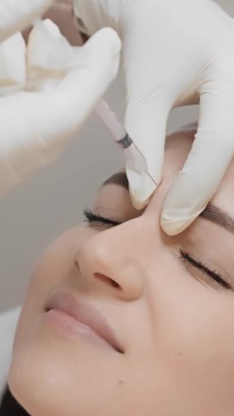 妇女享受肉毒素注射的过程 在整个过程中感到皱纹和面部表情的减少 美容师对病人实施肉毒毒素疗法 — 图库视频影像