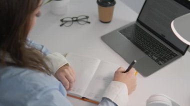 Genç bir kadın, görevlerini verimli bir şekilde tamamlamak için dizüstü bilgisayar kullanarak evden eğitim ve çalışma teknolojisi uyguluyor. Yaratıcılık sürecine dalan serbest yazar dizüstü bilgisayar kullanır ve fikirleri hayata geçirir.