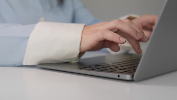 テーブルのノートパソコンのキーボードにタイピングする女性の手のクローズアップ 女性はオンラインでコンピュータで働き 研究しています オフィスまたは自宅で電子文書を使用する 高品質4Kについて — ストック動画