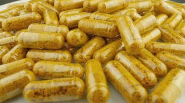 İlaç içeren temiz kapsüller dönüşümlü olarak sağlık ve tedaviyle ilişkilendirilir. Açık Kapsüllerdeki zerdeçal ve Curcumin: Doğal Malzemeler Arasında Sağlıklı Bir Yaşam Tarzına Ulaşmanın Bir Yolu