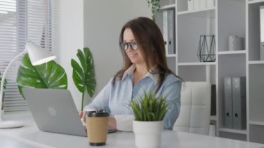 Bu videoda, teknolojiyi kişisel gelişimi için güvenle kullanan bir kadın görüyorsunuz. Çevrimiçi kurslar okuyarak ve bir kişi olarak gelişerek yeni fırsatlar keşfetmeye çalışıyor.