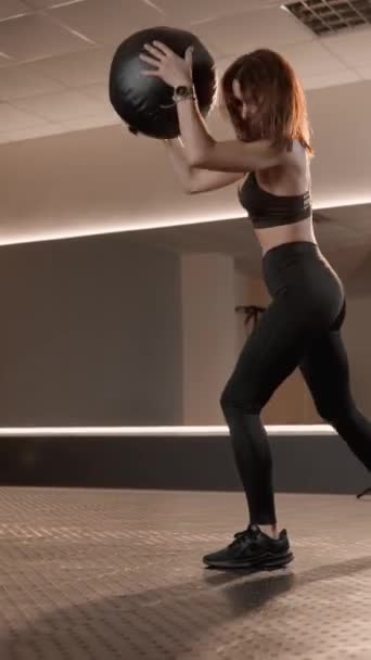 用一个重球状药物球进行训练 以发展肌肉 并提高身体的整体健康水平 一个女人带着巨大的精力和自信去完成一个复杂的训练项目 — 图库视频影像