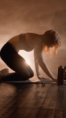 Esnekliği ve rahatlığı korumak için esneme hareketi. Genç bir kadın kaslarını gevşetmek ve vücudunun esnekliğini geliştirmek için esneme hareketleri sergiler. Rahatlatıcı bir atmosferi olan video. Yüksek