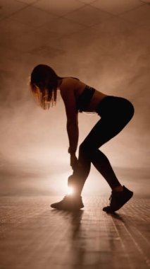 Koordinasyon ve dengeyi geliştirmek için işlevsel kettlebell eğitimi. Genç bir bayan atlet fiziksel yeteneklerini geliştirmek ve geliştirmek için çeşitli kettlebell egzersizleri yapar.